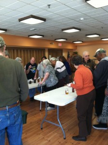 Seniors tasting the different varieties of honey that Cathy brought to the Quail Brook Senior Center as part of the beekeeping presentation in observance of National Agriculture Day.